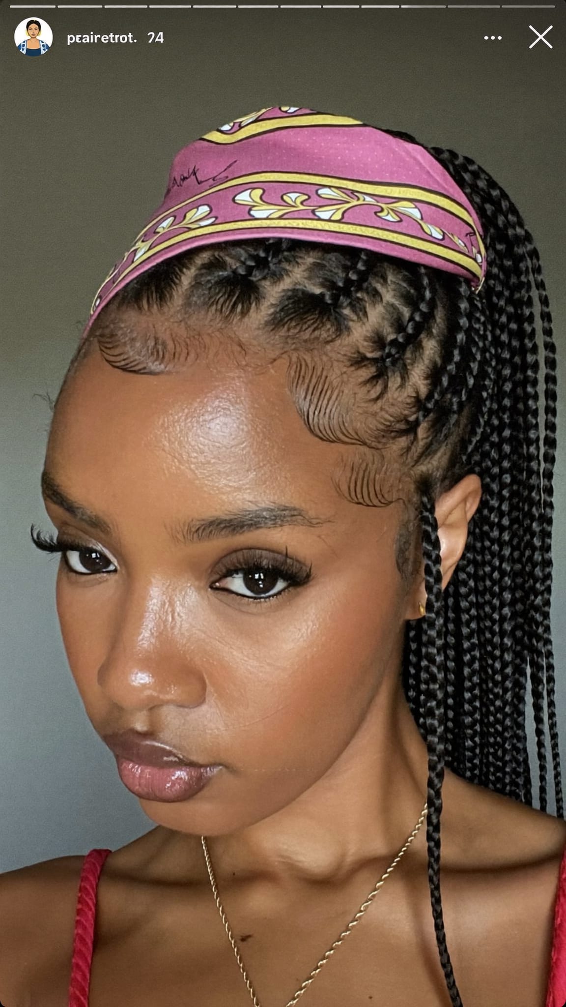 Black woman with box braids half-up half-down with a printed silk bandana tied as a crown around the half-up section