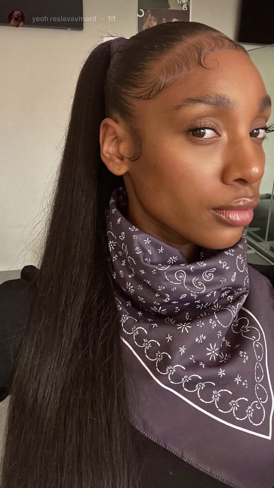Black woman with long sleek high ponytail wearing a large bandana wrapped over most of her hair in the iconic 90s Aaliyah style