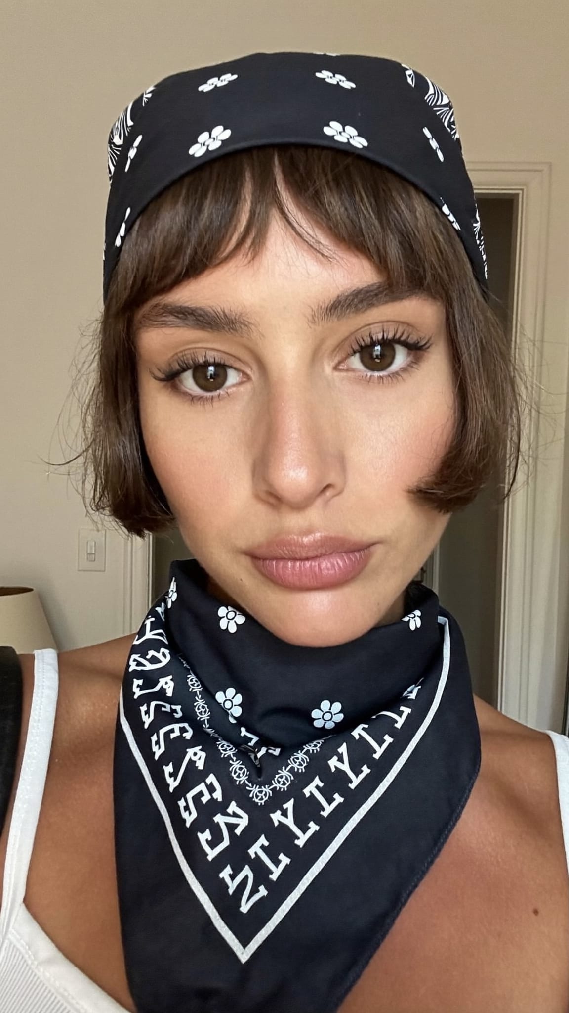 White woman with very short baby bangs wearing a Y2K punk style bandana in a half-wrap style