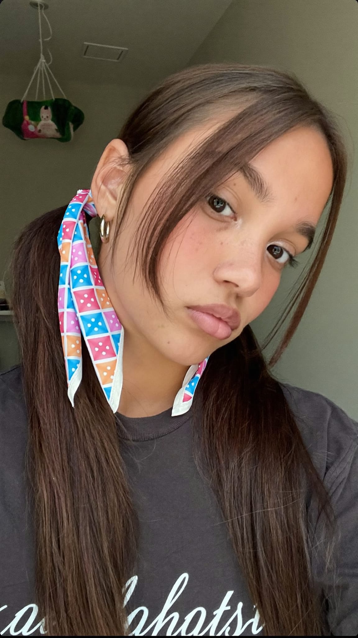 Young teen girl with pigtails, each tied at the base with a colorful triangle bandana in pink and blue