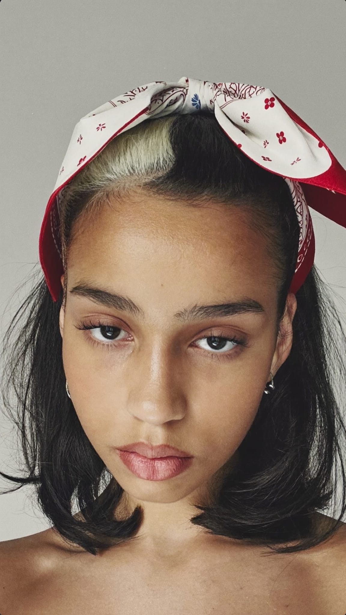 Teen girl with half-up half-down hairstyle, a printed square satin bandana tied around the top section