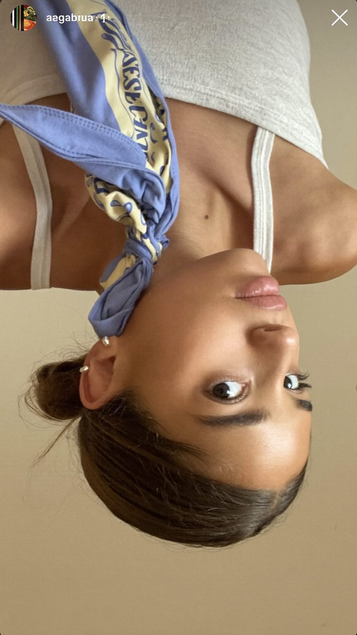 Teen girl with a low bun, a soft cotton printed bandana wrapped around the bun and tied in a bow at the back