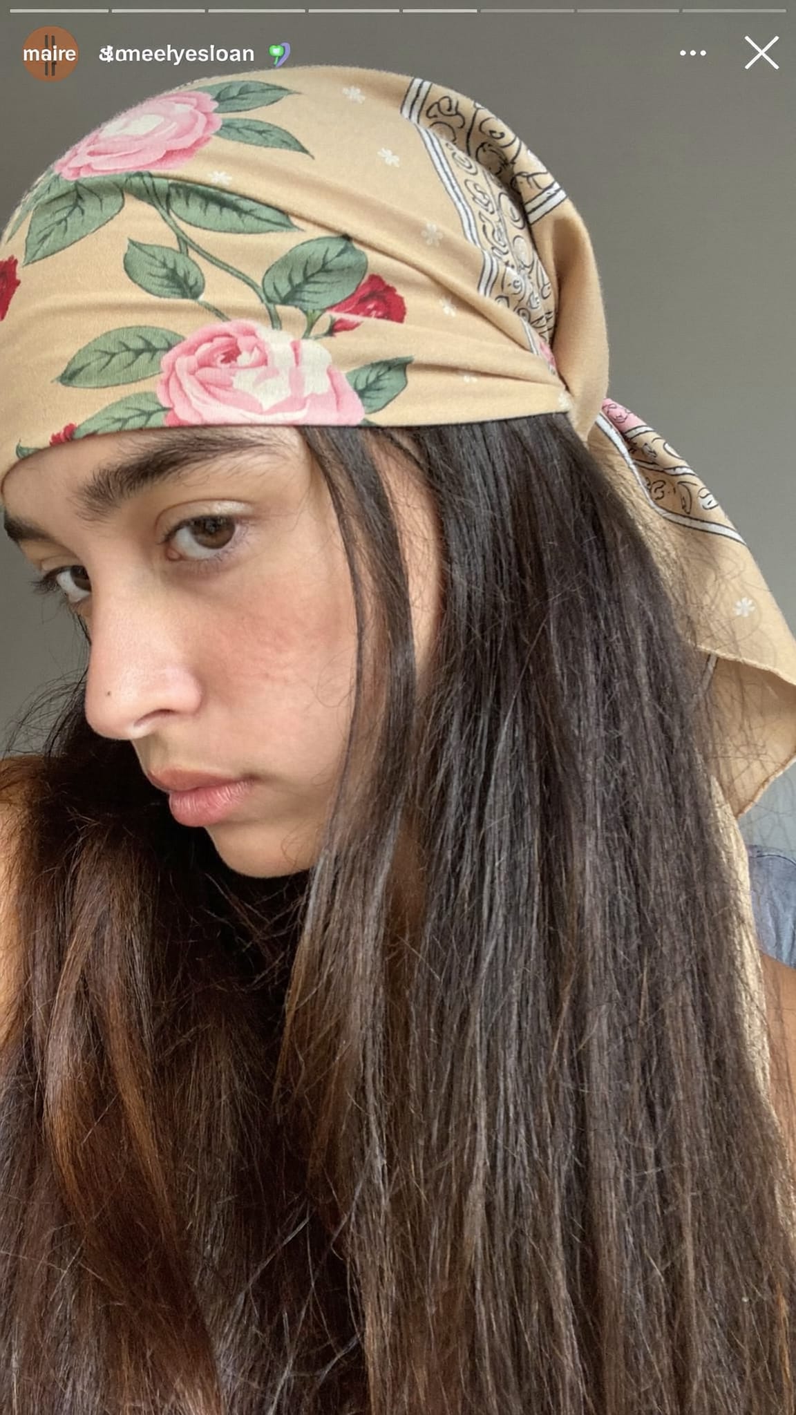 Teen girl with long thick dark hair, a floral boho triangle bandana wrapped around her head with the knot at the back