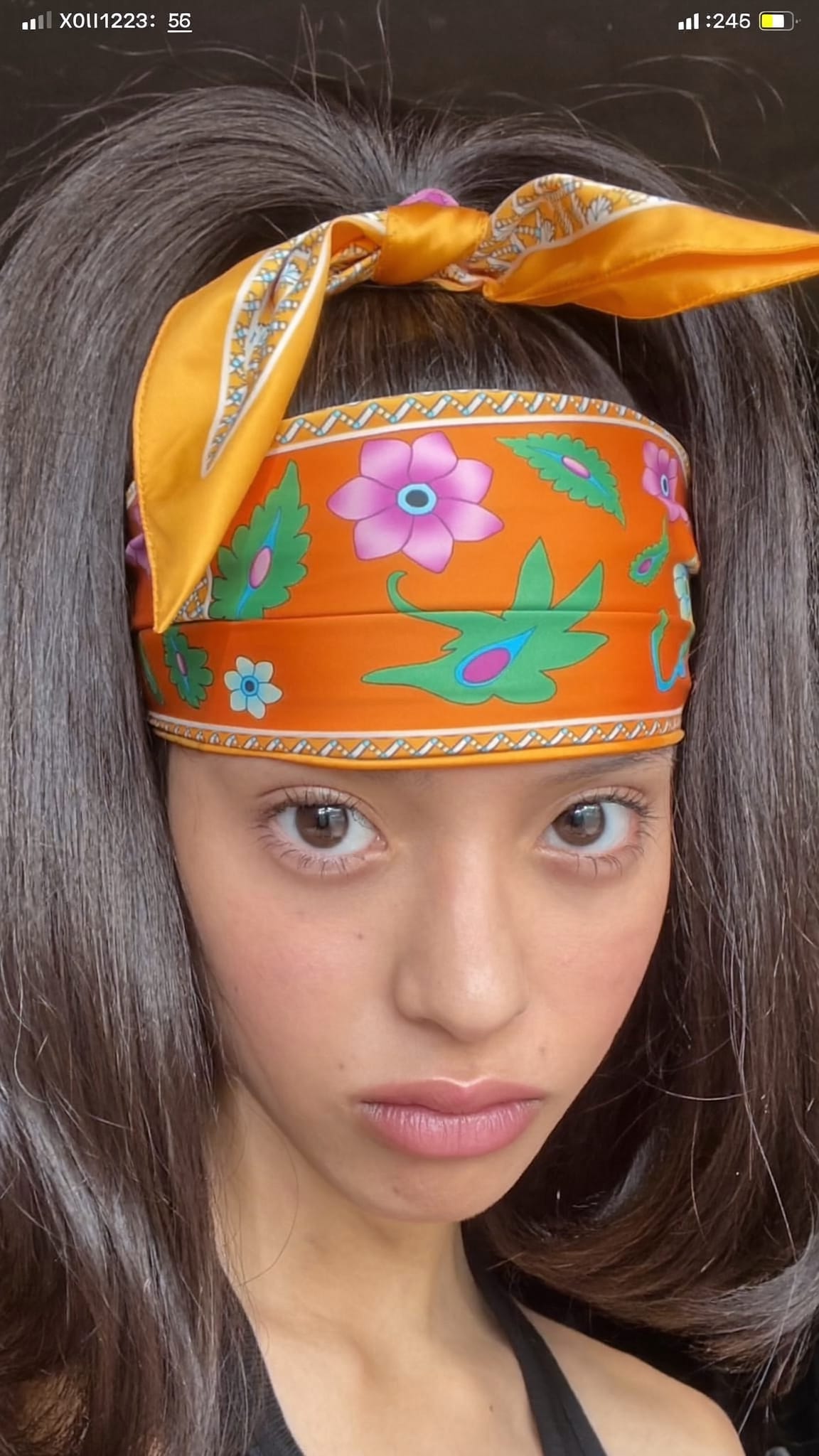 Teen girl with very high ponytail, a bright satin island-print bandana tied in a big bow at the very top
