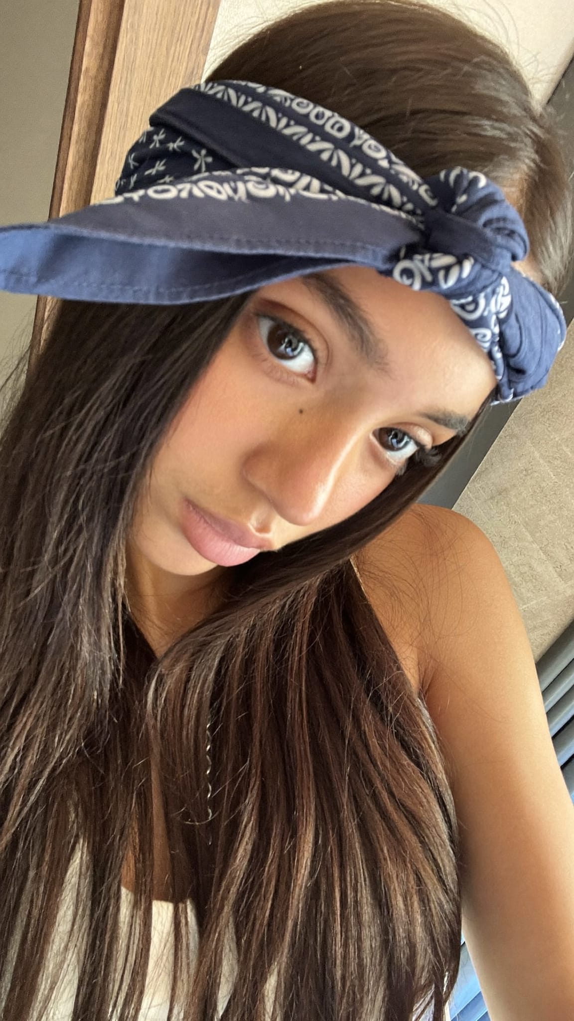 Young Latina teen with long straight hair, a printed cotton bandana knotted at the top of her head