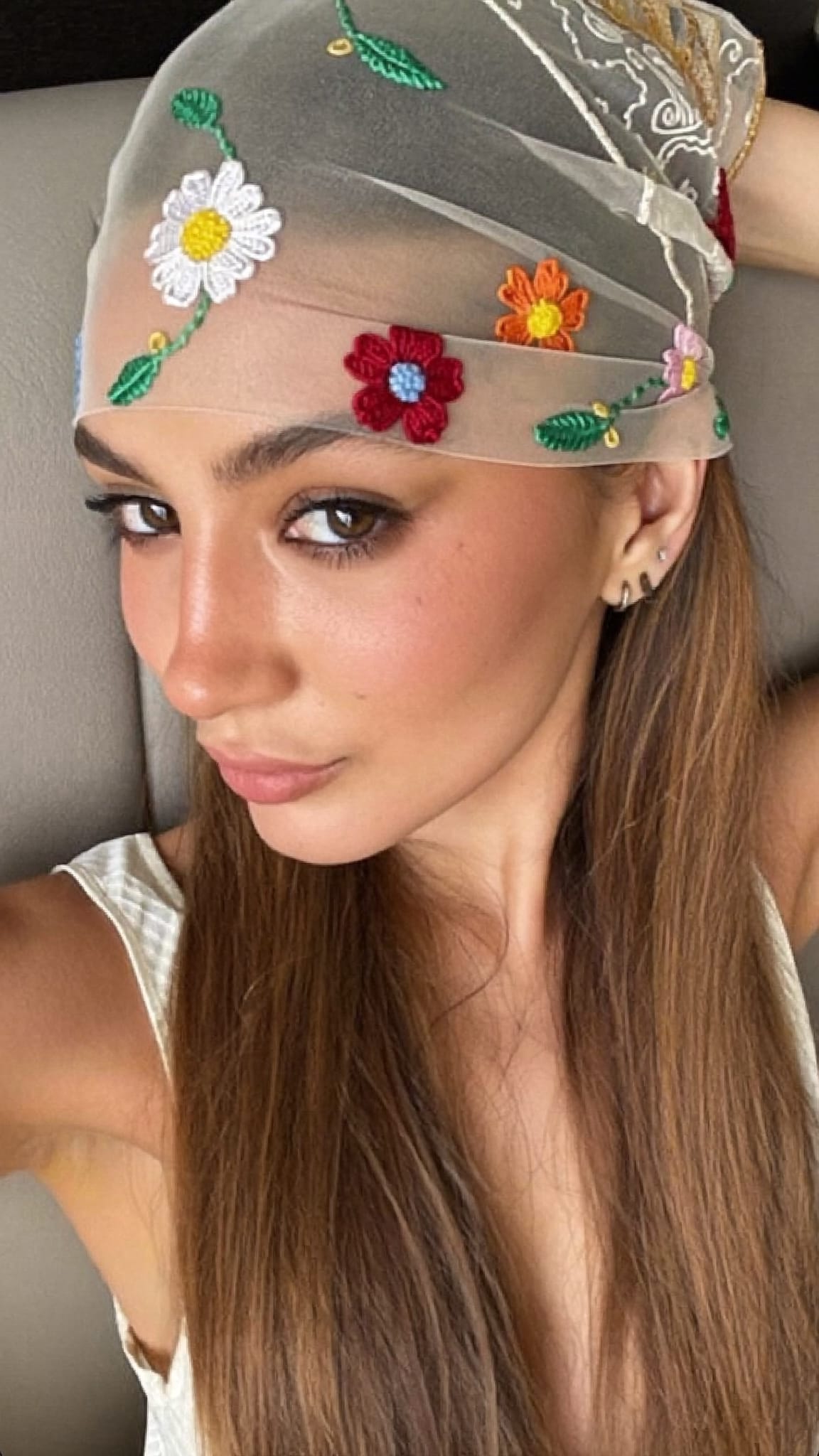 Woman with fair skin and long hair in a half-up style with a sheer lace flower embroidery bandana layered over the top section