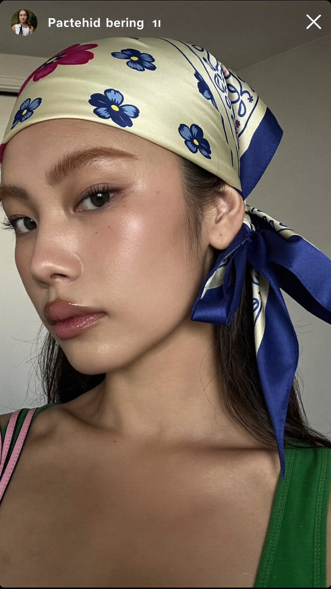 East Asian woman with sleek straight hair wearing a floral satin bandana tied in a soft side bow above one ear