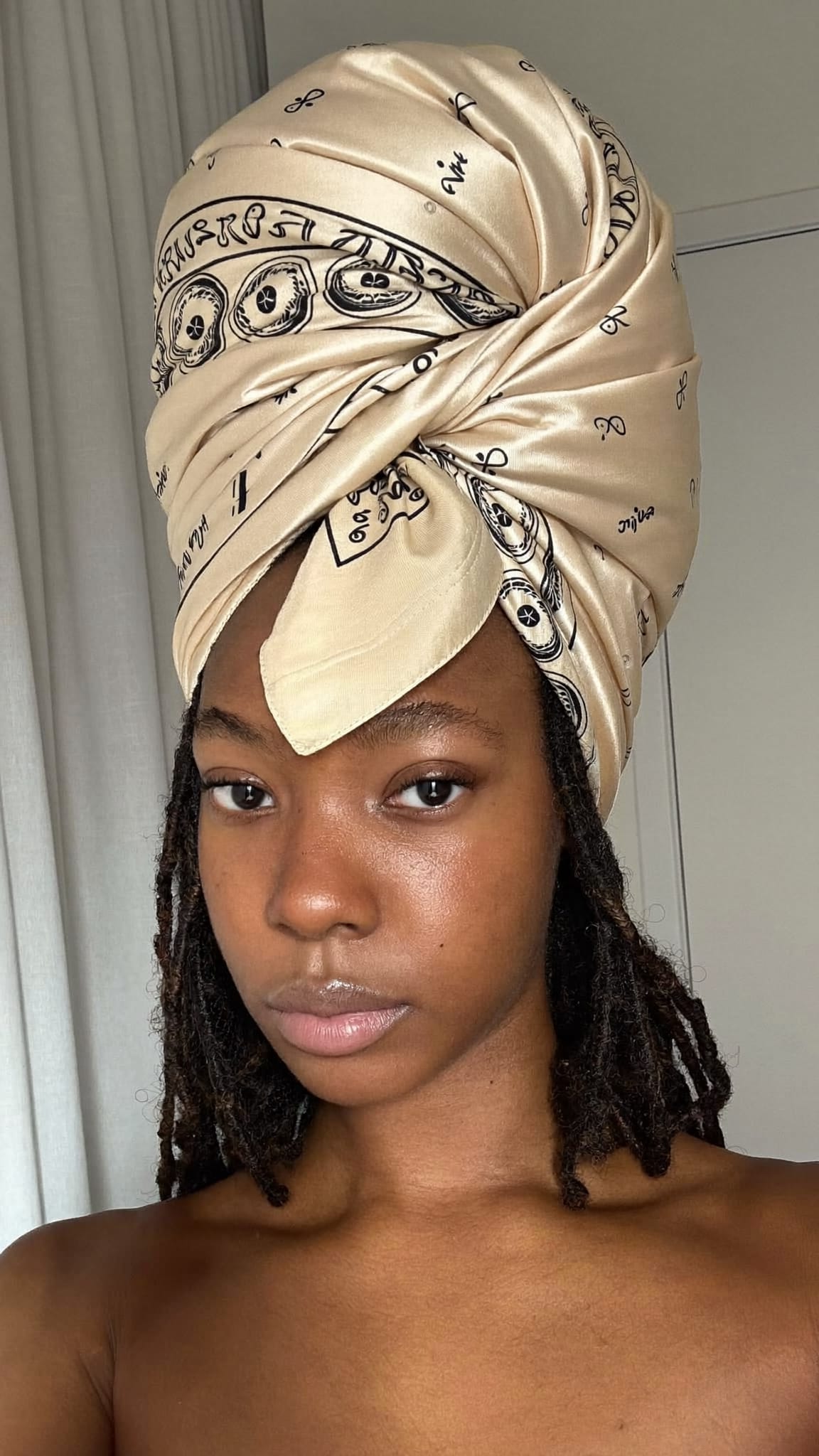 Woman with deep brown skin and locs wearing a large 35-inch satin bandana wrapped as a full turban